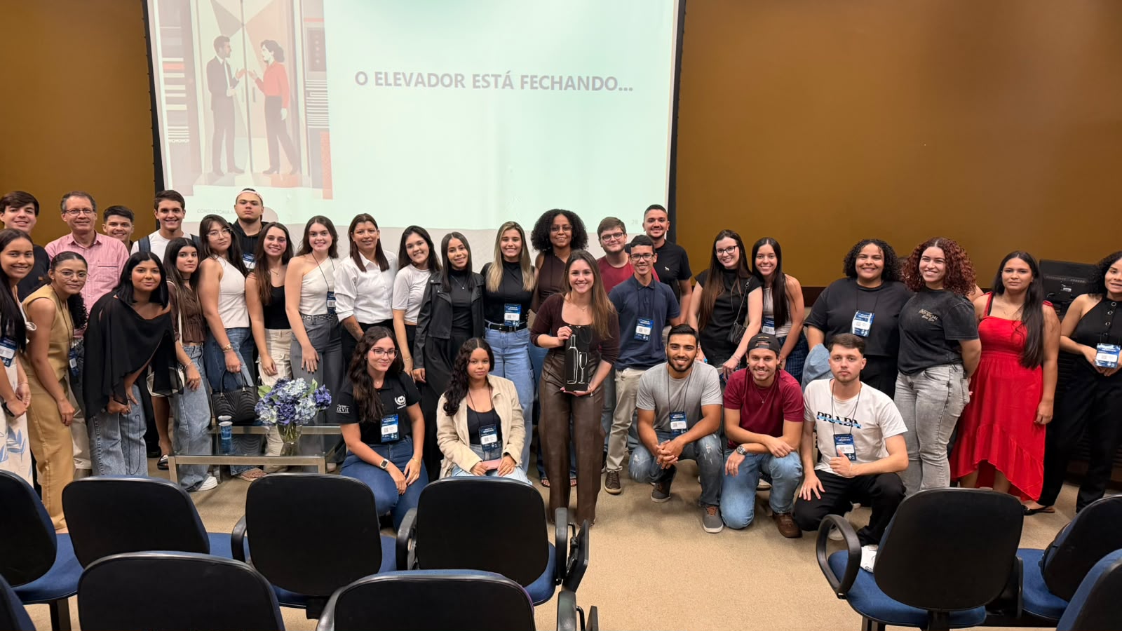 Laura e uma turma reunida em auditório