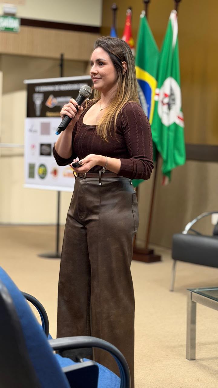 Laura Morico falando ao microfone em um evento